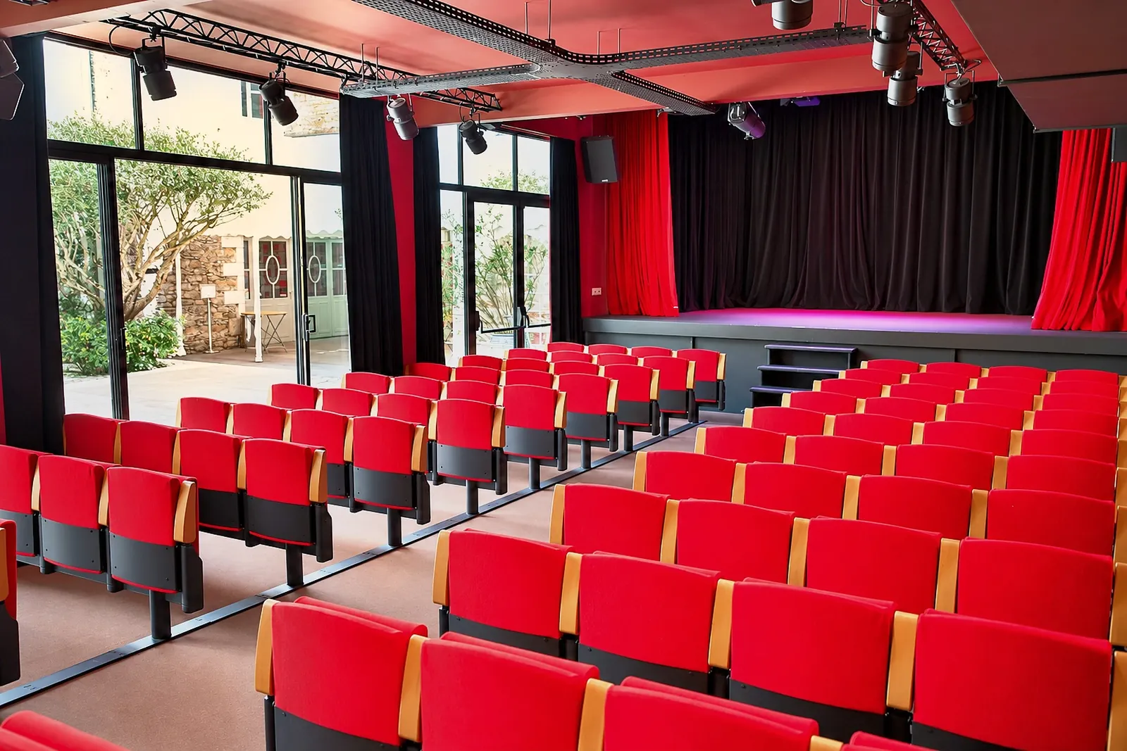 La Compagnie Events - Location de salle Nantes 1 Auditorium à Nantes avec gradins de fauteuils rouges et scène à rideau de velours